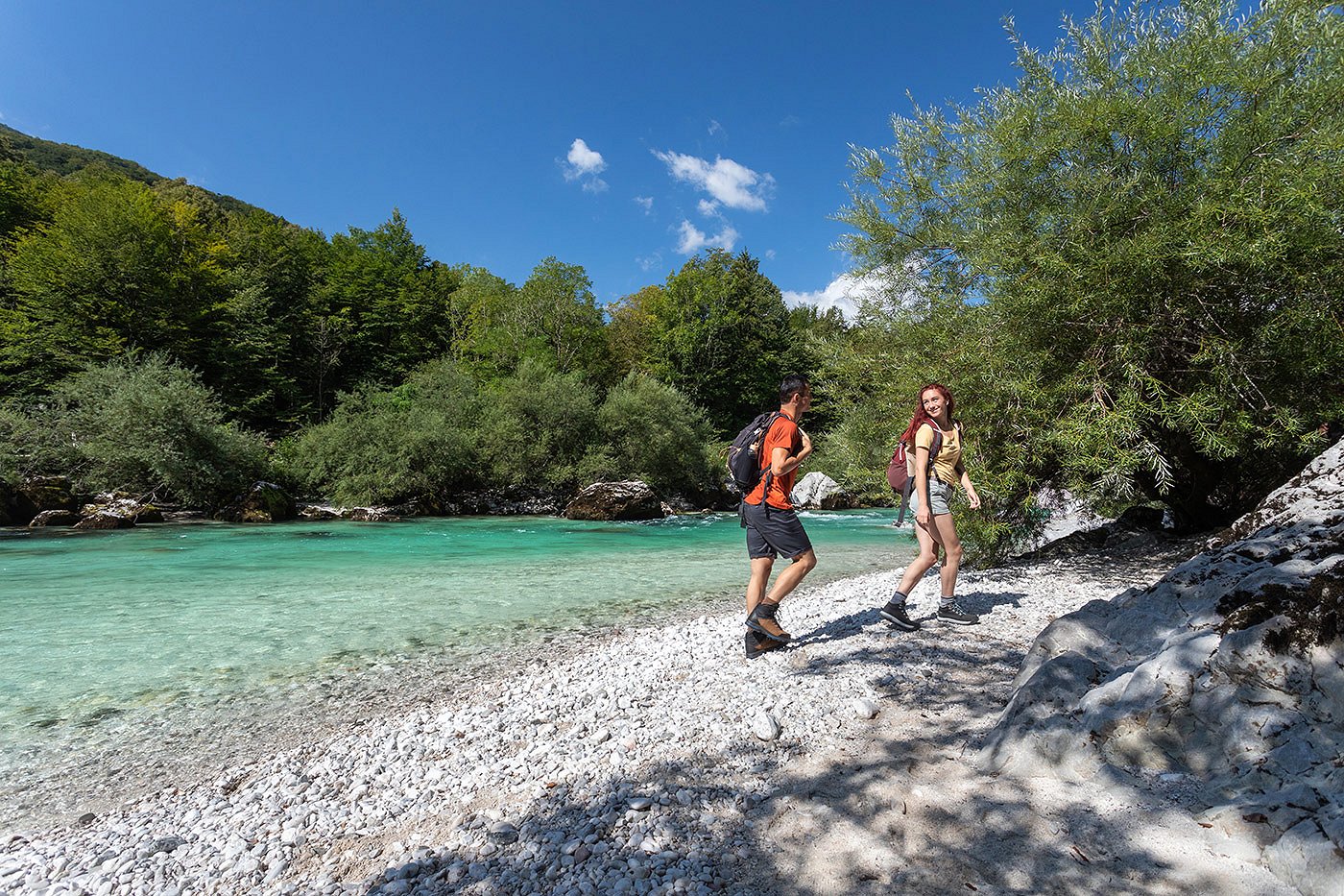 Hiking in the Soča Valley The hikers are walking along the sandy bank of the Soča River
