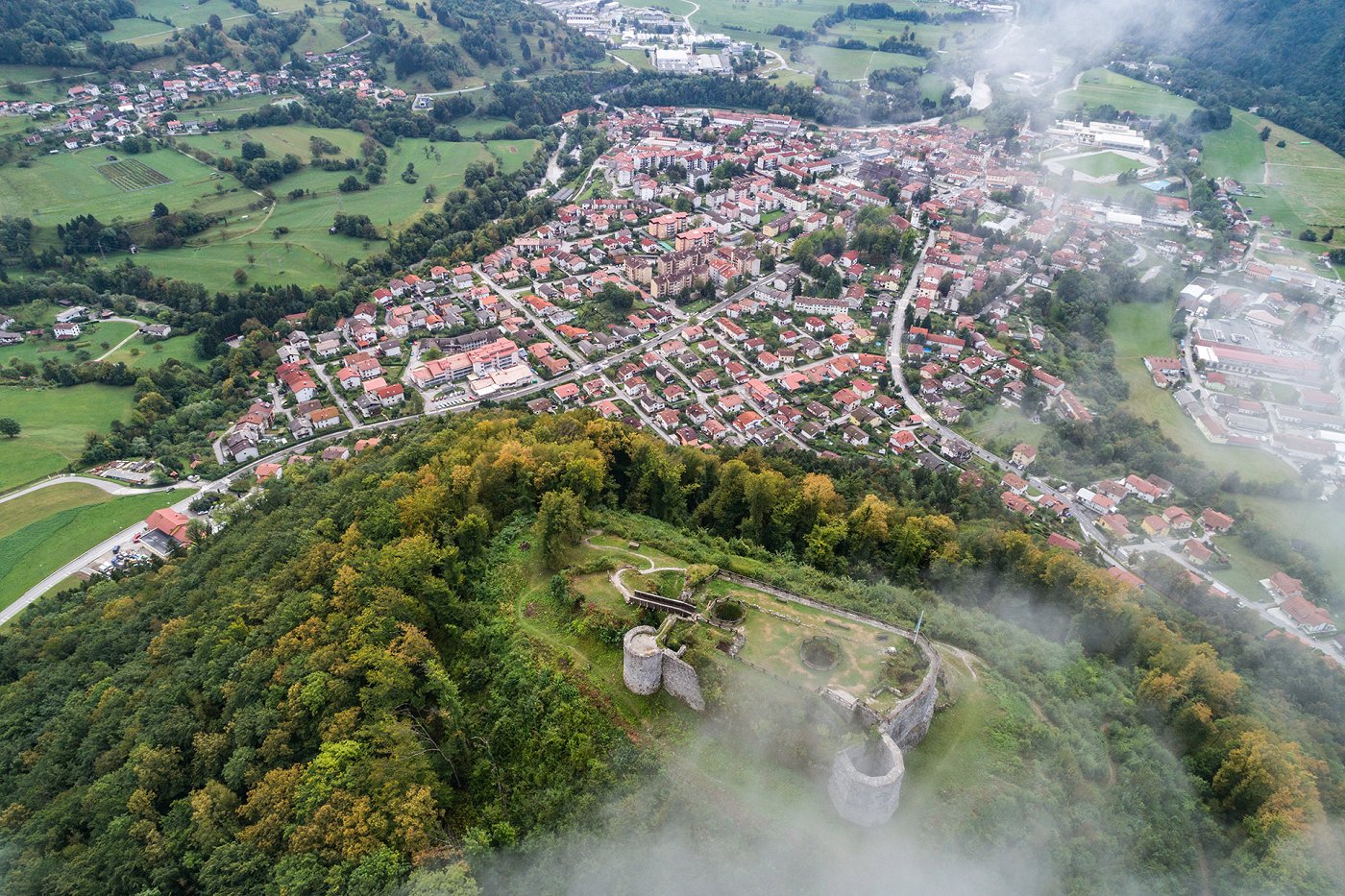 Pogled iz ptičje perspektive na ostaline gradu na griču Kozlov rob ter mesto Tolmin v dolini