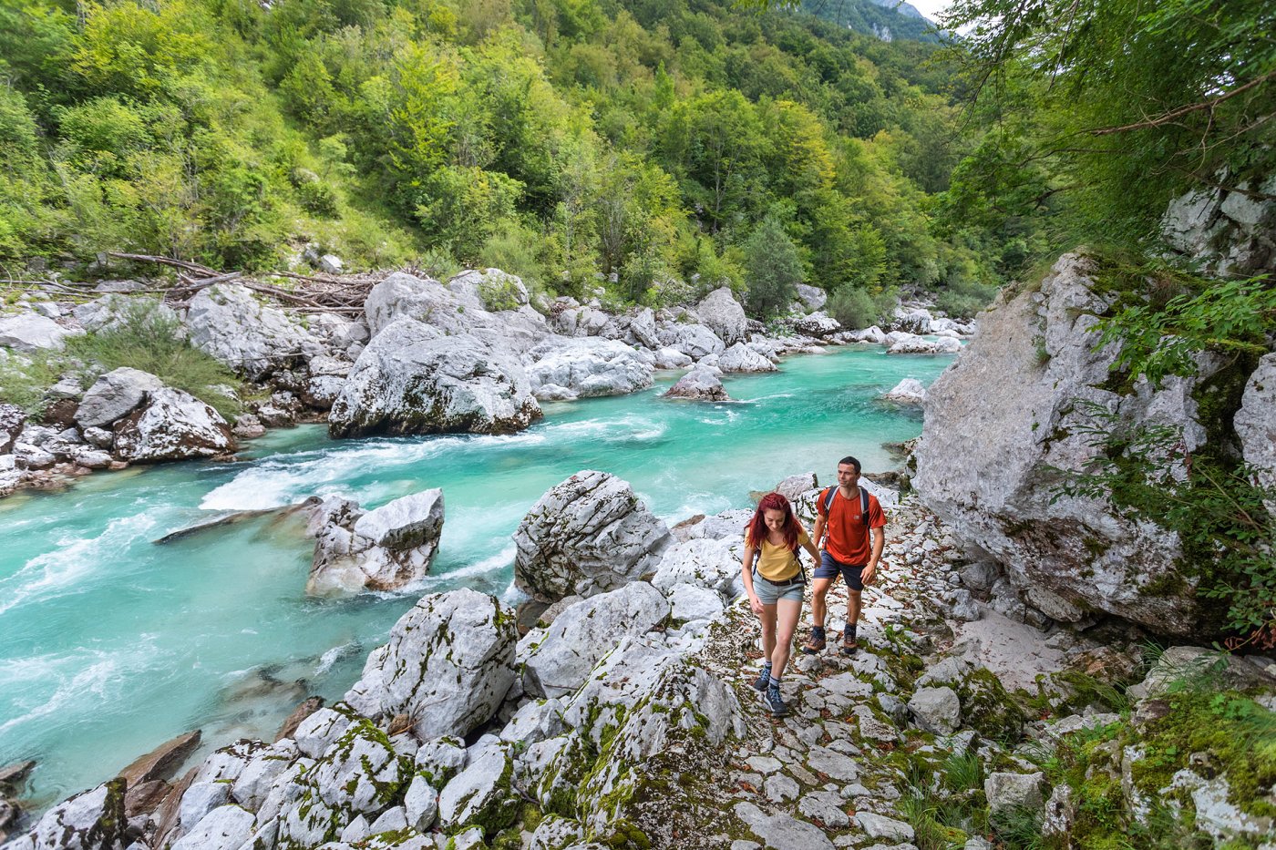 Gli escursionisti camminano lungo il sentiero Juliana Trail lungo il fiume Isonzo color smeraldo